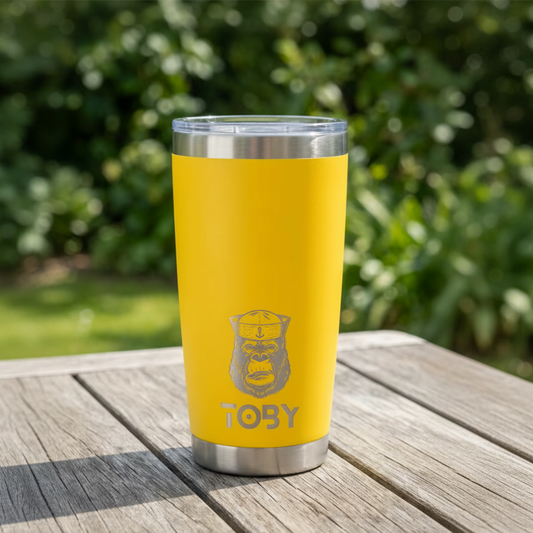 Yellow tumbler with silver lid on a wooden surface outdoors